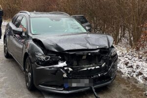Zwei beschädigte Autos nach Frontalzusammenstoß, Polizei vor Ort, Verletzte werden versorgt.