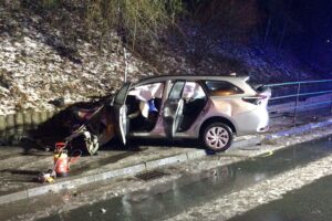 Schwerer Verkehrsunfall: Pkw prallt gegen Fahrbahnabtrennung, zwei Personen verletzt und gerettet.