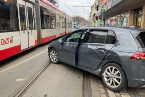 Zusammenstoß zwischen Straßenbahn und Pkw, Einsatzkräfte sichern Unfallstelle, Verkehrssperrung.