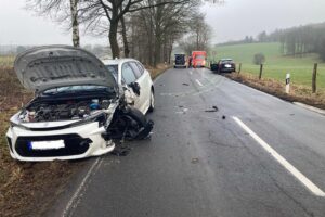 Zwei beschädigte Autos nach Unfall auf Happacher Weg, Polizei und Abschleppdienst vor Ort.