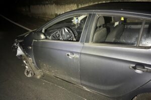 Unfallstelle mit beschädigtem Auto, Schutzplanke und Polizei, nachts auf Autobahnzubringer B10.