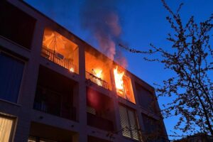 Brennende Wohnung in Senioreneinrichtung, Feuerwehr vor Ort, Einsatzkräfte retten Bewohner.