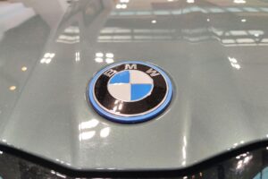 BMW-Logo auf neuem i5, symbolisiert Innovation und wirtschaftliche Herausforderungen in der Automobilbranche.