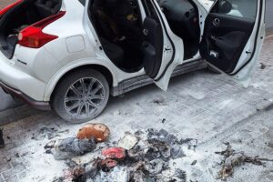 Bautrupp löscht brennenden Pkw, Feuerwehr kontrolliert Brandstelle nach schnellem Eingreifen.
