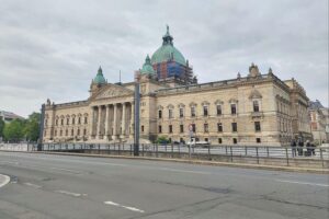 Ein Jurist spricht im Gericht, umgeben von Symbolen der Justiz und Rechtsstaatlichkeit.