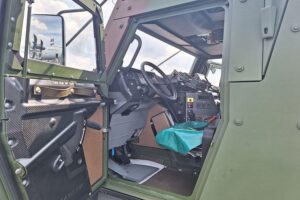 Sanitätsfahrzeug der Bundeswehr, umgeben von militärischen Technik- und Kommunikationsproblemen, symbolisiert Herausforderungen.