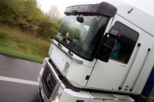 Lkw auf einer Straße, symbolisiert den Preisanstieg im Dienstleistungssektor und Transport.