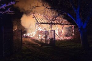 Feuerwehr im Einsatz, löschende Scheune, Rauchwolken über Feld, Gefahr gebannt, Sicherheit gewährleistet.