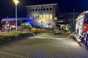 Freiwillige Feuerwehr übt Brandbekämpfung in Schulungsraum, zahlreiche Einsatzkräfte und Drehleiter im Einsatz.