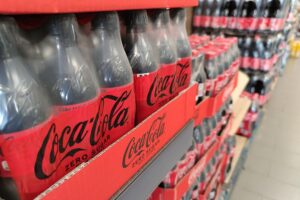 Coca-Cola-Produkte im Supermarkt: Diskussion über Zuckersteuer für gesunde Ernährung und Kostenersparnis.