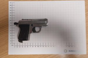 Bundespolizisten sichern geladene Schusswaffe während Kontrolle am Bahnhof Paderborn.
