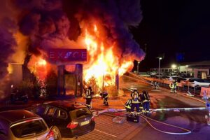 Großbrand im Fitnessstudio: Feuerwehr kämpft gegen Flammen, evakuiert 18 Personen erfolgreich.
