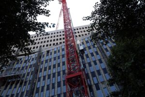 Baustelle mit Förderhinweisen für sozialen Wohnungsbau und kritischen Plakaten zur Bundesregierung.