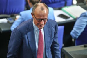 Friedrich Merz spricht im Parlament; Umfrageergebnisse zu Parteien und Zufriedenheit dominieren die Diskussion.