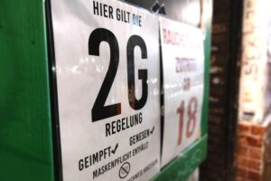 2G-Hinweisschild an einer Bar, symbolisiert Corona-Maßnahmen und rechtliche Auseinandersetzungen in Deutschland.