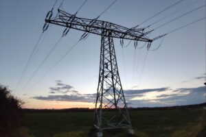 Strommast vor dramatischem Himmel; Symbol für zunehmende Angriffe auf kritische Infrastruktur in Deutschland.