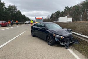 Verunfallter Nissan auf Autobahn, Unfallstelle mit Polizei und Unfallspuren im Fokus.