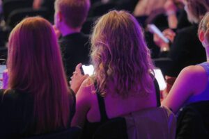 Junge Menschen nutzen Smartphones, um soziale Medien aktiv zu gestalten und zu nutzen.