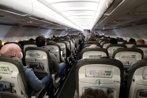 Flugpassagiere warten am Flughafen während der Coronakrise auf ihre Flüge und Regelungen.
