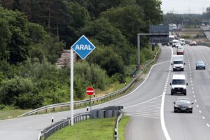 Autobahn mit Tankstelle, Umweltschutz, Tempolimit-Diskussion, autofreie Sonntage, Verkehr und Nachhaltigkeit.