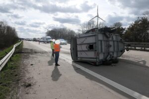 Pferdeanhänger nach Unfall auf sich liegend, Autobahn gesperrt, Feuerwehr und Tierärzte im Einsatz.