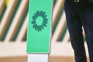 Grünen-Logo vor einem politischen Hintergrund, symbolisiert innerparteiliche Debatten und Kurskorrekturen.