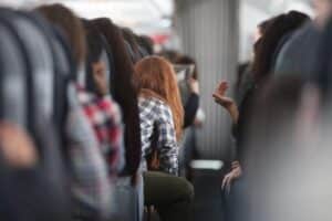 Frau im Flugzeug, symbolisiert Luftverkehrssteuer-Senkung und steigende Passagierzahlen in Deutschland.