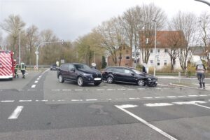 Unfallstelle mit beschädigten Autos, Einsatz von Polizei und Rettungsdienst sichtbar.