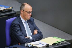Friedrich Merz spricht vor Publikum, während politische Spannungen im Nahost-Konflikt thematisiert werden.