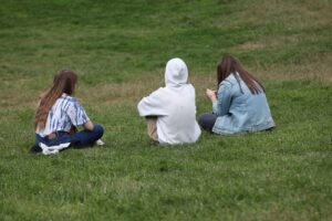 Drei junge Frauen im Park, symbolisieren Chancengleichheit und Gesundheitsförderung für Frauen.