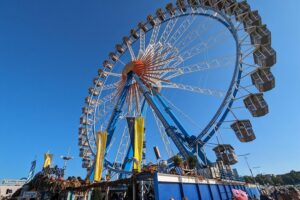 Traditionelles Fest mit Bier, Trachten, Menschenmengen und Fahrgeschäften symbolisiert deutsche Kulturvielfalt und Zusammenhalt.