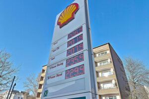 Shell-Tankstelle mit hohen Benzinpreisen, symbolisiert Preiserhöhungen durch Kriegsausnutzung und Übergewinnsteuerforderung.