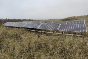 Solarzellen auf einem Dach mit Sonnenlicht, symbolisieren erneuerbare Energien und Stromproduktion.