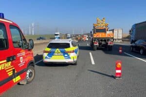 Schwerer Verkehrsunfall auf Autobahn 7, beschädigter BMW, Trümmerfeld und Verletzter.