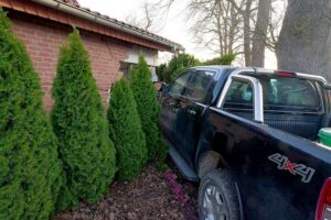 Zwei beschädigte Pkw, Feuerwehr an Einsatzstelle, verletzte Personen und Garage im Hintergrund.