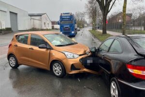 Zwei verletzte Autos an Straße, Polizei und Rettungswagen vor Ort, mehrere Personen betroffen.