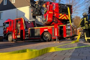 Zimmerbrand in Bad Meinberg: Feuerwehr im Einsatz, zwei Personen verletzt, starker Rauch sichtbar.