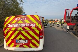 Feuerwehrkräfte sichern gefährliche Substanz im Postverteilzentrum; Einsatz folie in Schutzkleidung.