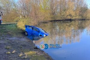Ein Auto steht teilweise im Wasser eines Teiches in Sendenhorst bei Nacht.