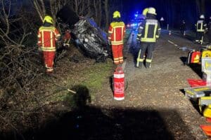 Verunfalltes Auto auf dem Dach, Einsatzkräfte retten eingeklemmte Person bei Verkehrsunfall.