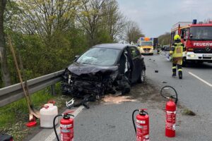 Schwerer Unfall auf Bundesstraße: Auto kollidiert mit Lkw, Straße gesperrt, Verletzte.