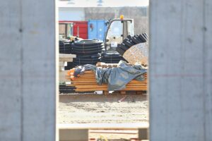 Baustelle mit Bauarbeitern und Maschinen, symbolisiert den Rückgang und die Herausforderungen im Baugewerbe.