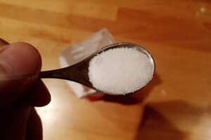Ein Zuckergefäß mit Label, das die geplante Zuckerabgabe und deren Kontroversen symbolisiert.