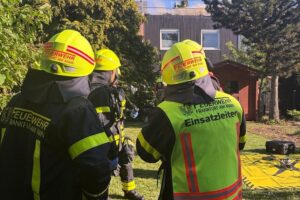 Feuerwehr im Einsatz bei Dachstuhlbrand in Frankfurt, Flammen und Rauch sichtbar.