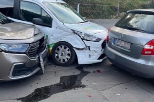 Verkehrsunfall mit zwei Fahrzeugen, Rettungskräfte im Einsatz, leicht verletzte Insassen.