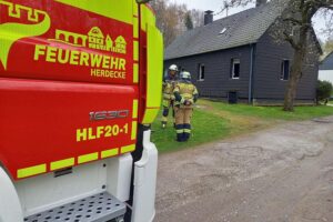 Feuerwehr bei Einsätzen: Schwelbrand in Einfamilienhaus, Rauchentwicklung, Nachbarn alarmieren, keine Verletzten.