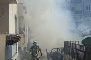 Brand eines Pkw im Hinterhof mit Feuerwehr im Einsatz, mehrere Fahrzeuge betroffen.