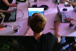 Junge Menschen spielen Videospiele, während digitale Risiken thematisiert werden.