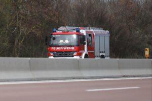 Feuerwehr im Einsatz, löschender Brand, beschädigte Objekte und Fahrzeug in Anger.