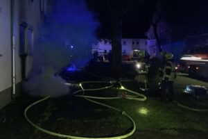Kellerbrand in Mehrfamilienhaus: Feuerwehr rettet Bewohner, Einsatzkräfte sichern das Gebiet ab.
